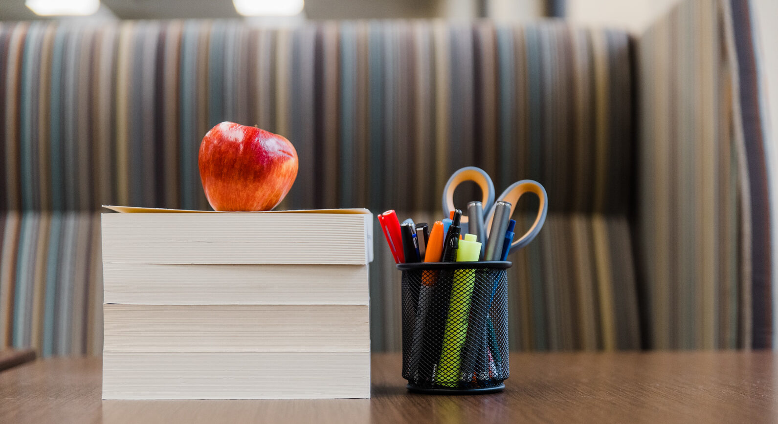 Book stack with an apple and school suppplies