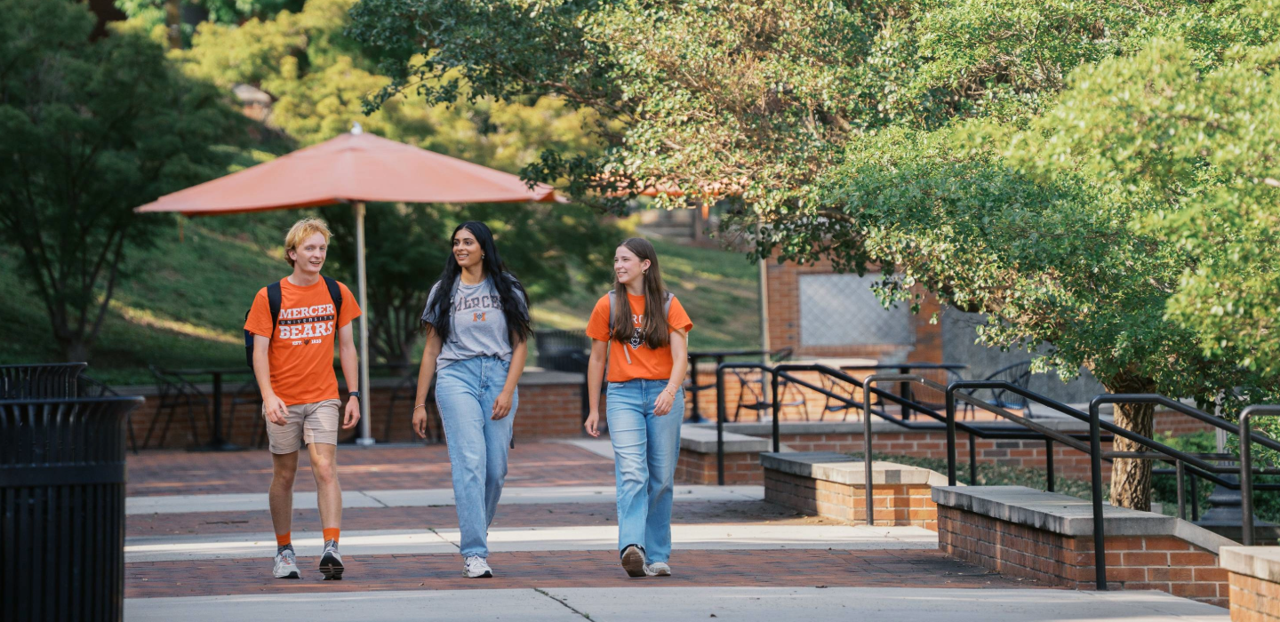 three students walking outside on campus